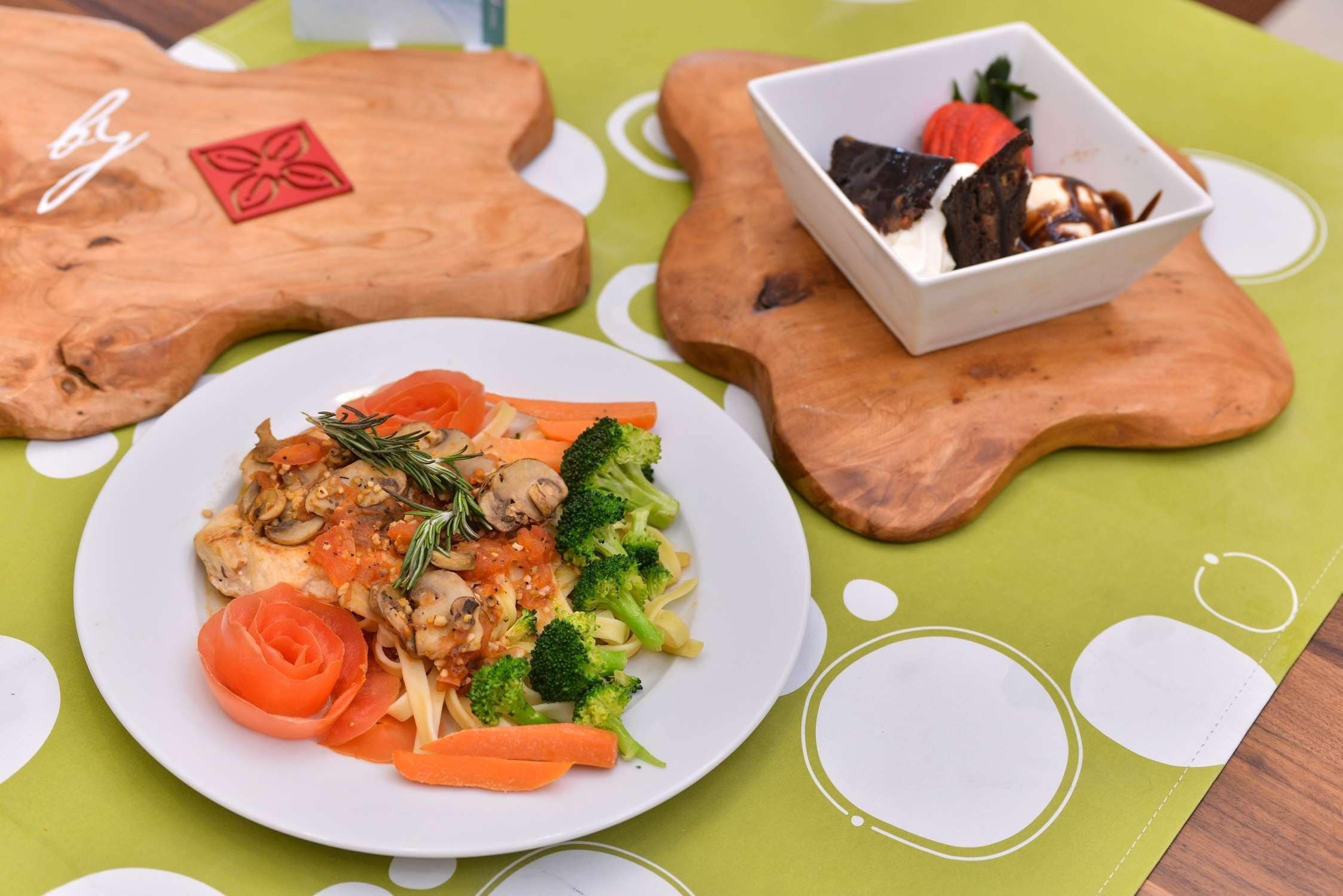 A plate of food on a green tablecloth with a wooden design.