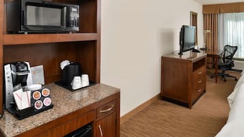 Une chambre d’hôtel équipée d’une kitchenette, d’une télévision, d’un bureau et d’une chaise.