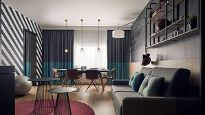 A modern living room with a grey sofa, a dining table with chairs, and a red circular rug. - HUP (Mierlo)