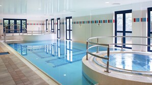 An indoor swimming pool with clear water, a hot tub, and tiled walls. - Parkavon Hotel (Killarney)