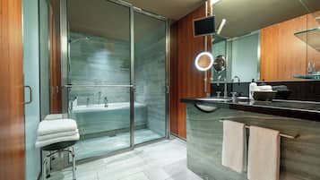 A modern bathroom with a glass shower enclosure, a vanity with a mirror, and a towel rack.
