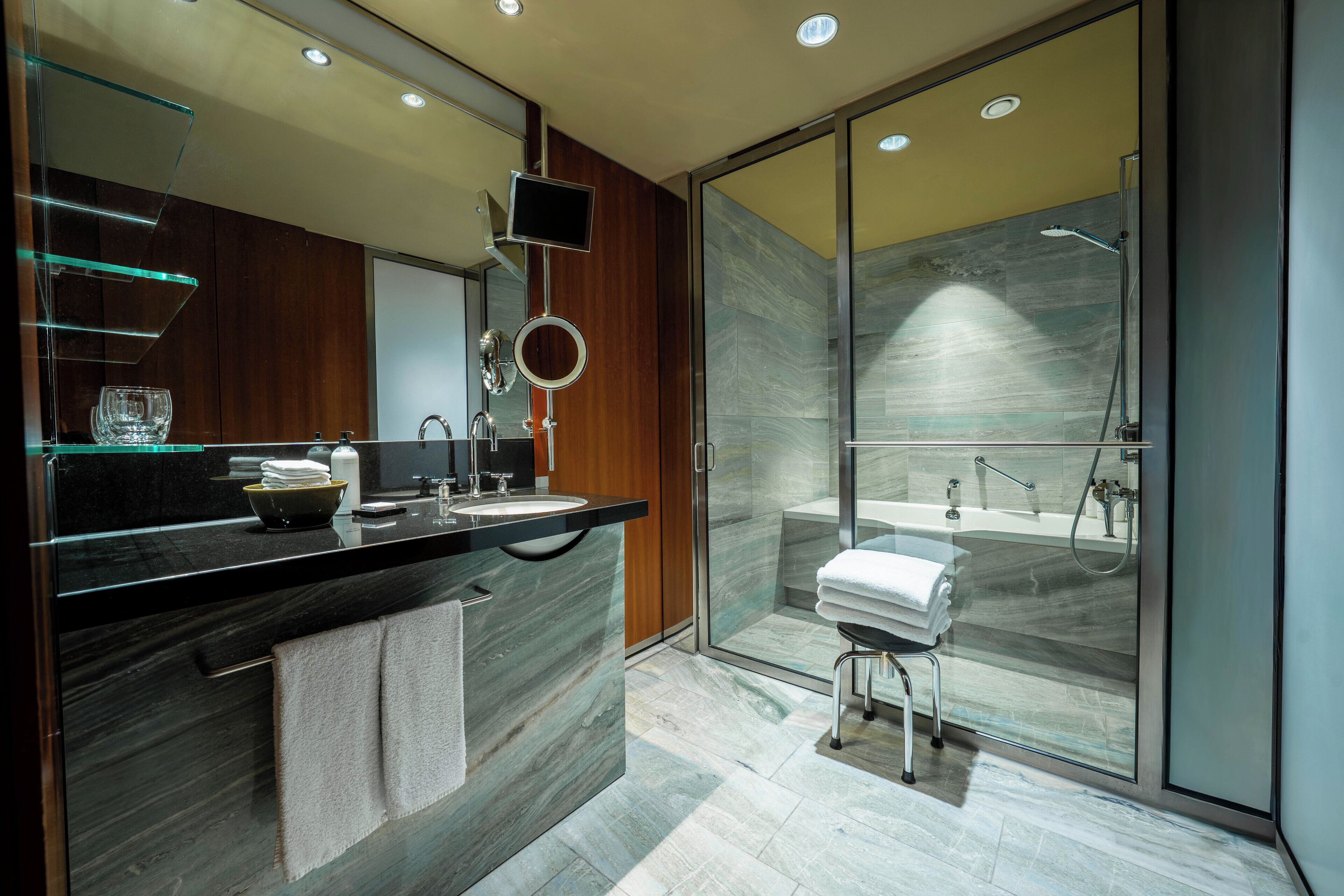 Une salle de bain moderne avec une douche à parois de verre, un meuble-lavabo avec un miroir et un évier.