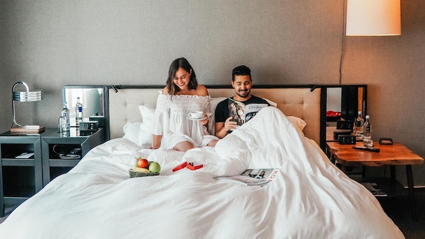 A hotel room with a bed, bedside tables, a lamp, and a mirror. - Grand Hyatt Berlin (Berlin)