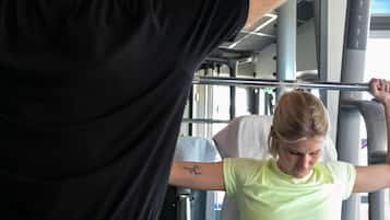 Une salle de sport équipée de matériel d'exercice, où une personne s'entraîne à l'aide d'un appareil à câbles.