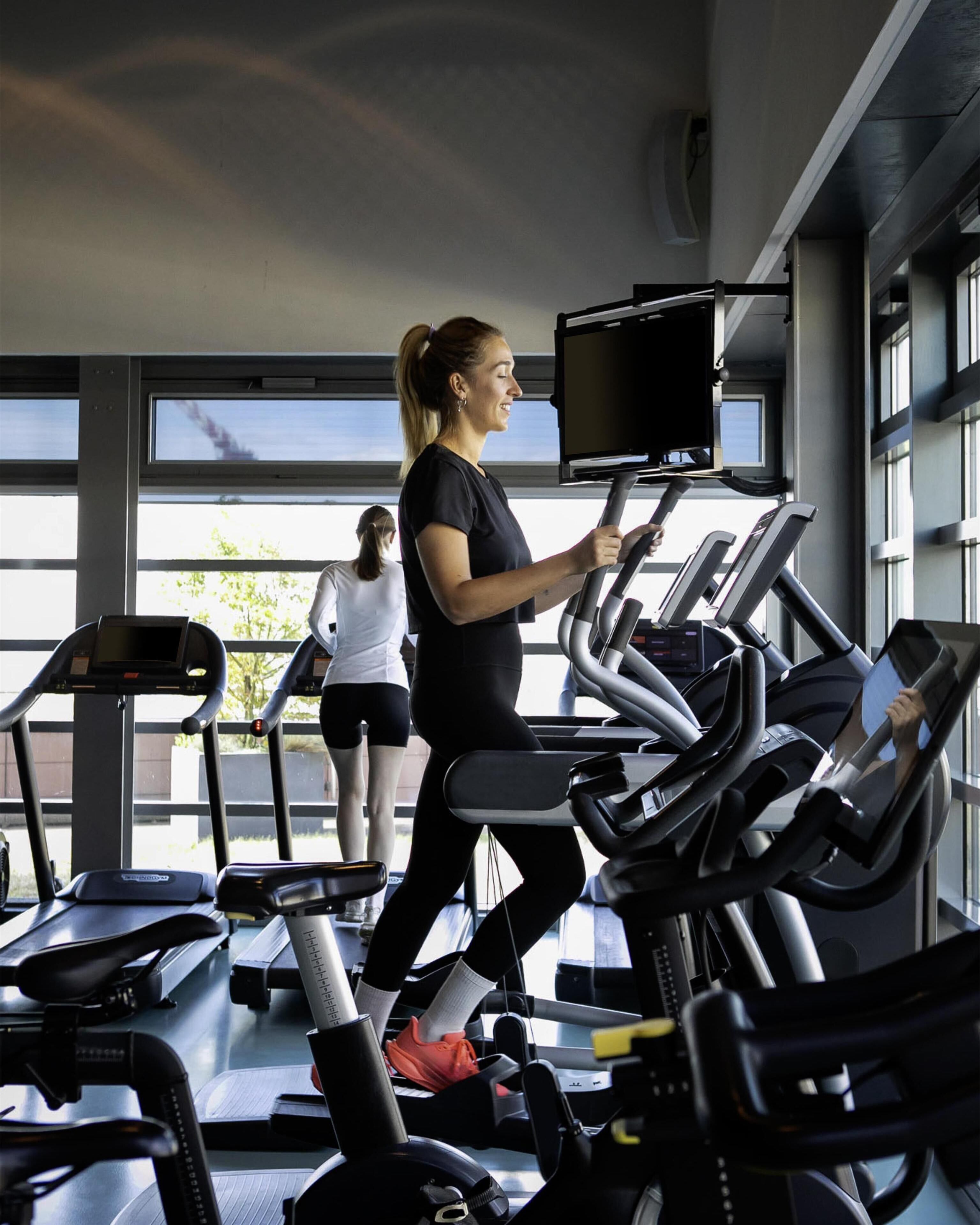 Ett gym med löpband och ett stort fönster.