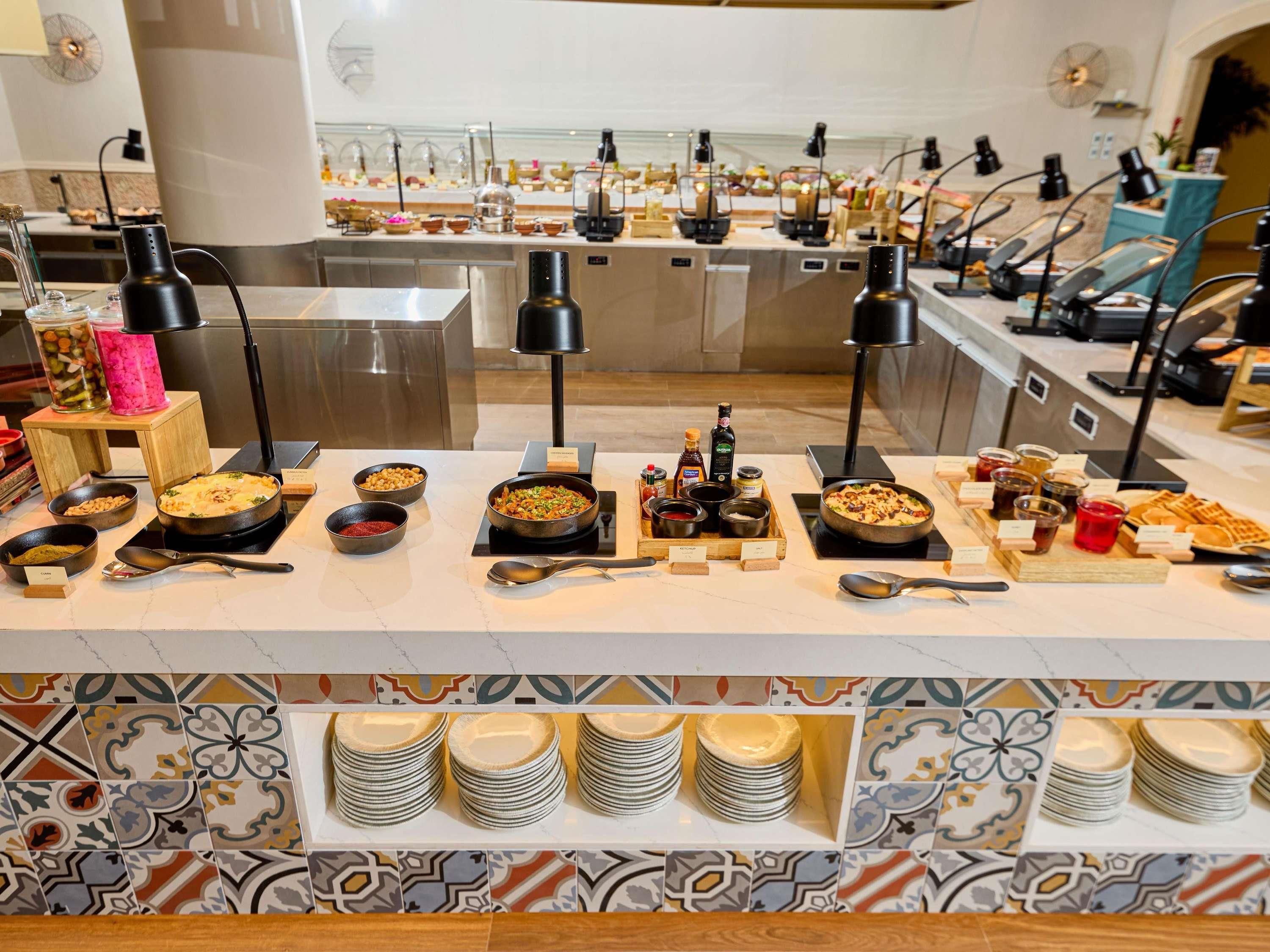 A buffet setup with various dishes, condiments, and utensils.