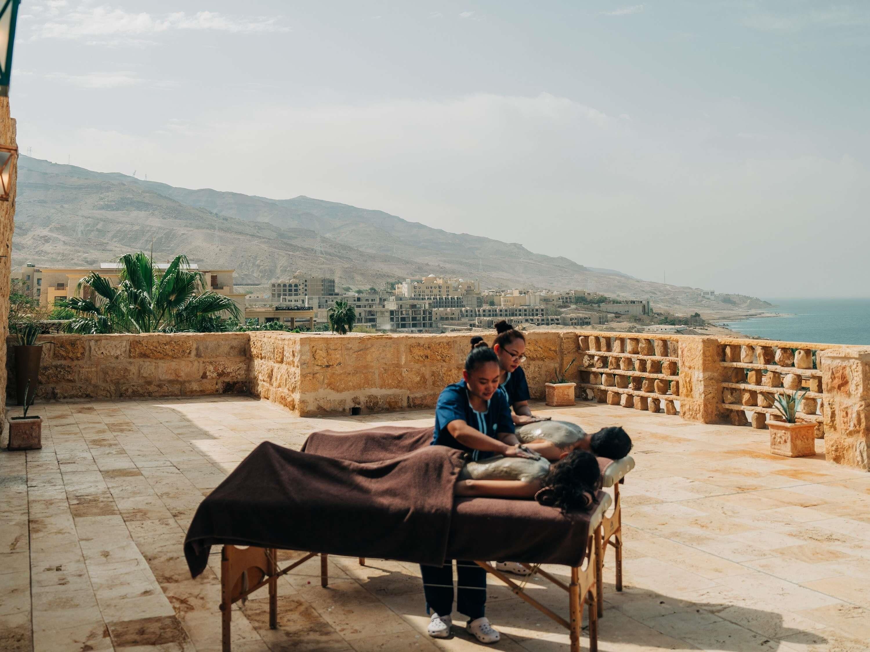 Un espace de massage aménagé sur le toit, offrant une vue sur la mer et les bâtiments.