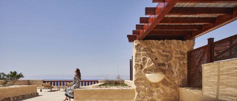 A woman sitting on a terrace with a view of the sea.