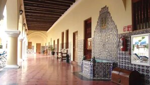 A corridor with tiled walls, wooden doors, and a tiled floor. - Holiday Inn Express Veracruz Centro Historico (Veracruz)