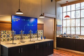 Een moderne badkamer met een blauw bord, meerdere wastafels en een raam met een rode hanglamp.