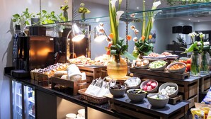 A buffet with various food items, a coffee machine, and decorative plants. - Crowne Plaza Liverpool City Centre by IHG (Liverpool)