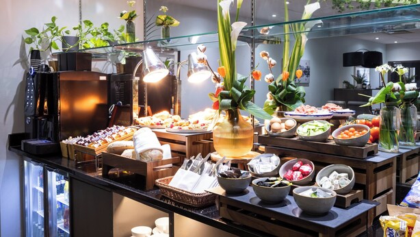 A buffet with various food items, a coffee machine, and decorative plants. - Crowne Plaza Liverpool City Centre by IHG (Liverpool)
