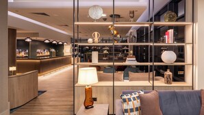 A modern hotel lobby with a bar area, seating, and a decorative shelf with various items. - Crowne Plaza Liverpool City Centre by IHG (Liverpool)