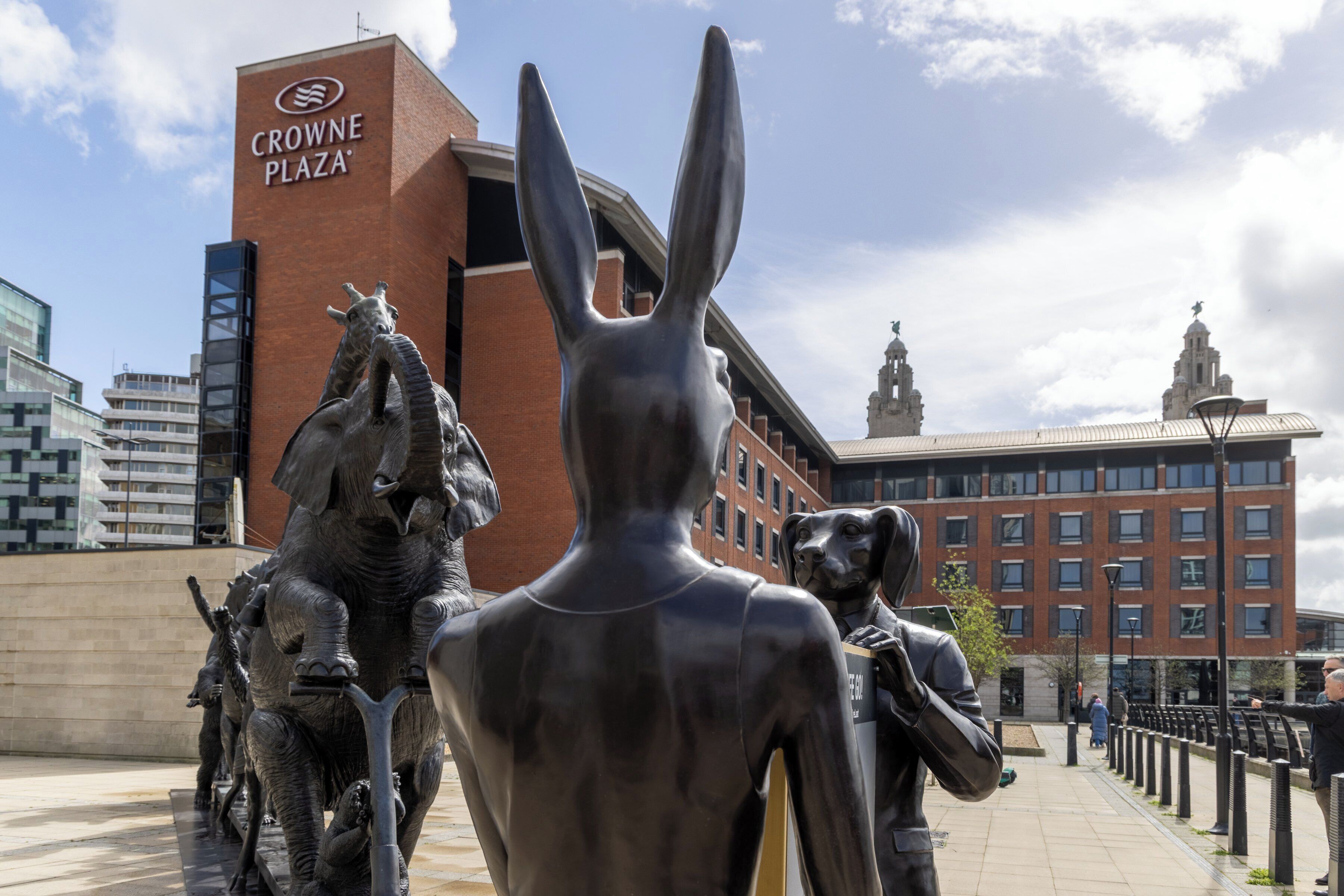 En skulptur som föreställer en kanin och en häst står framför en byggnad med en skylt där det står ”Crowne Plaza”.