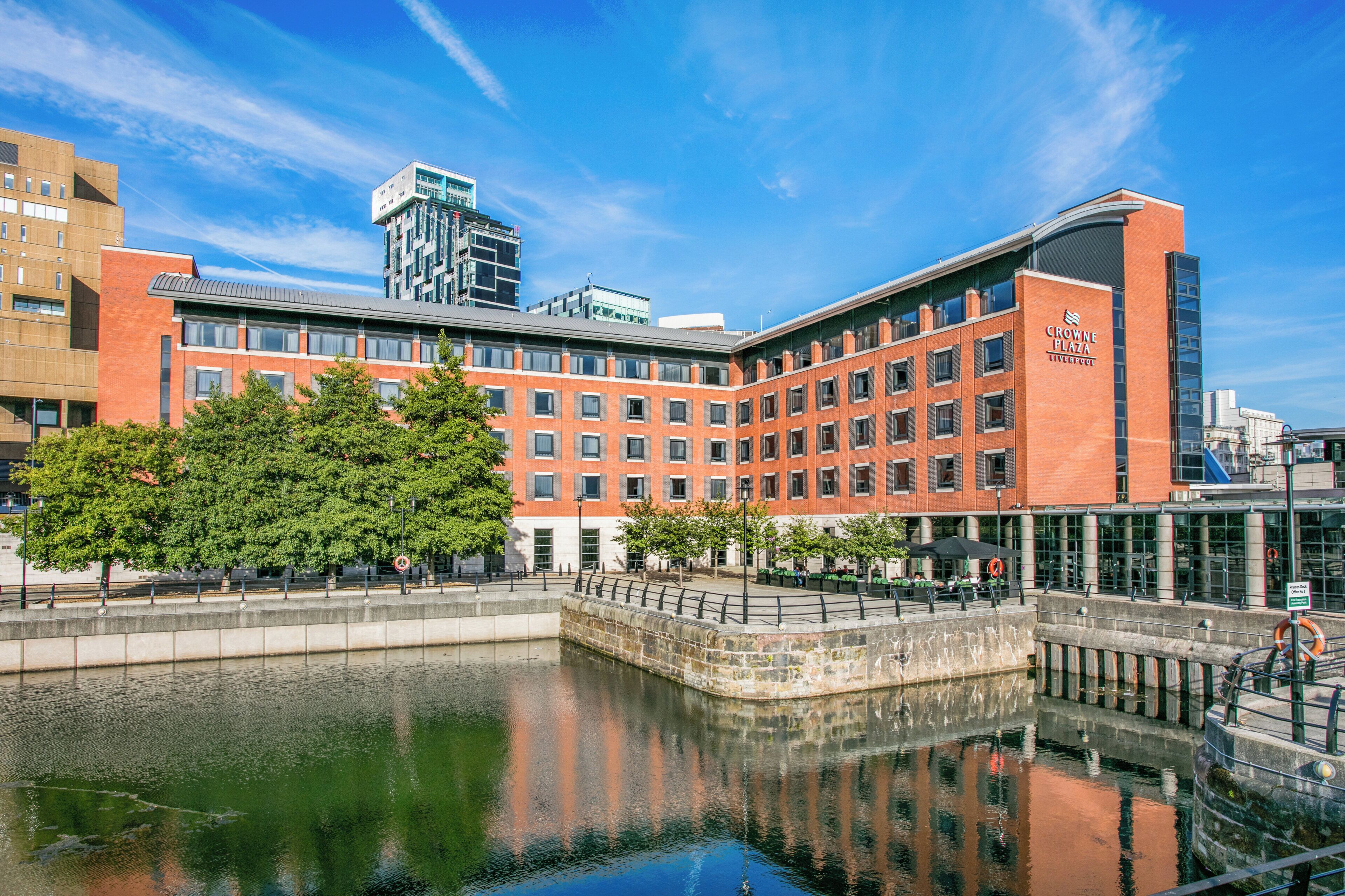 A modern building with a courtyard and a reflective water feature.