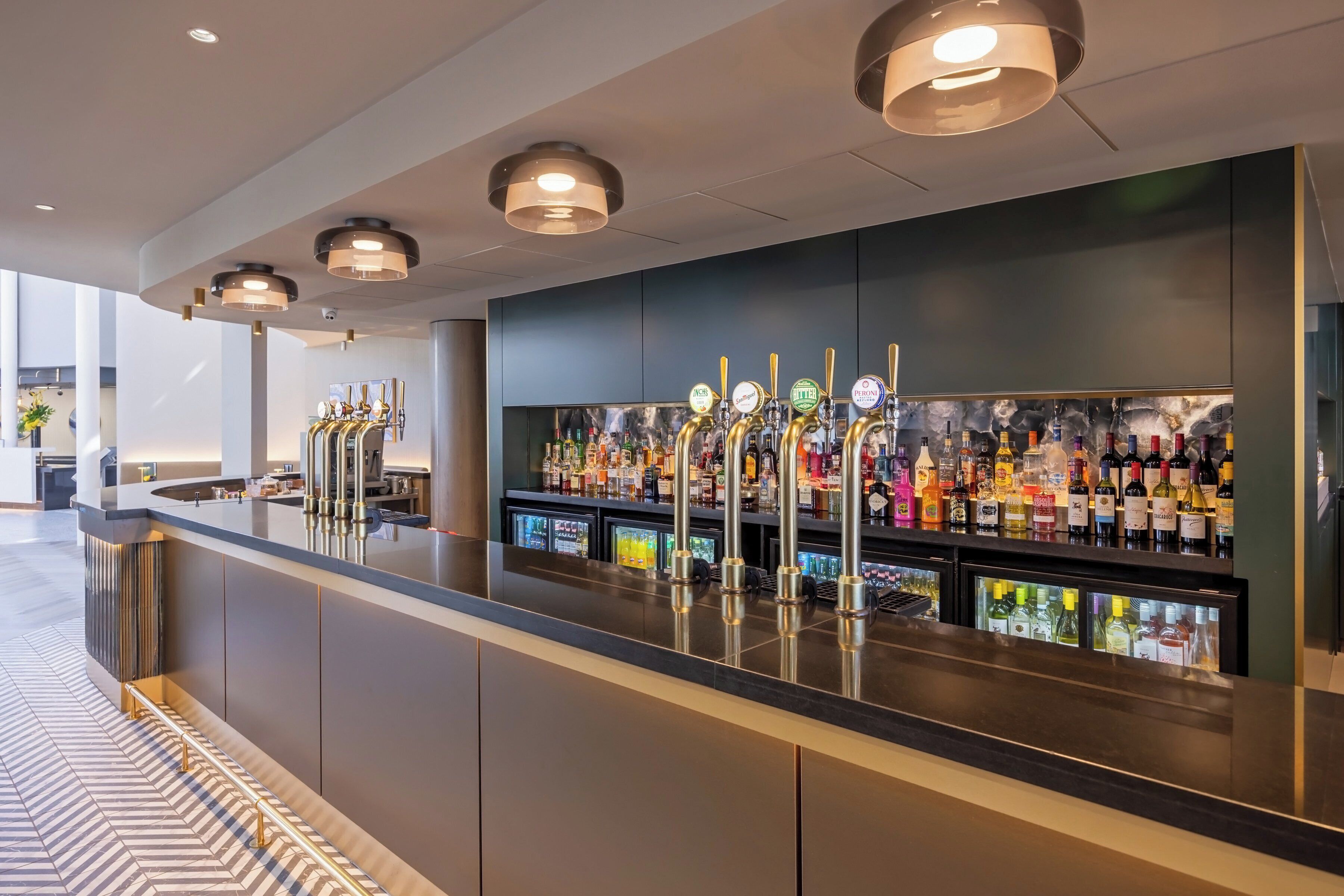 Un espace bar doté de nombreux robinets, d’un large choix de bouteilles et d’un design moderne.