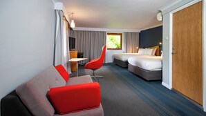 A hotel room with a bed, a sofa, a chair, a desk, and a wardrobe. - Holiday Inn Express Taunton East by IHG (Taunton)