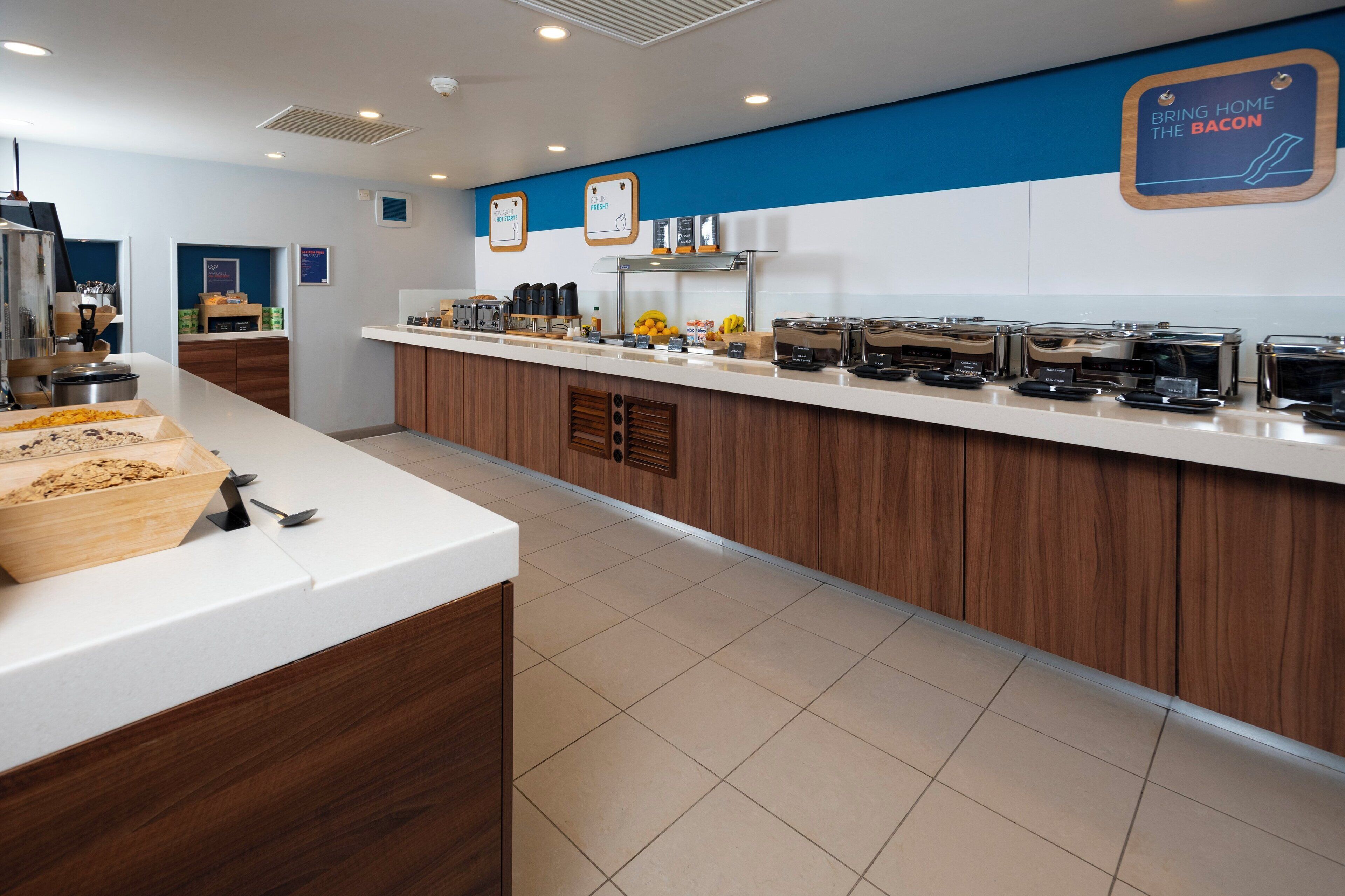 A breakfast bar with various food items and appliances.