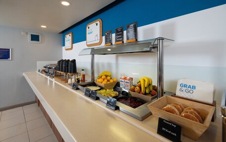 A buffet counter with various food items and a sign indicating 'Grab & Go' service.