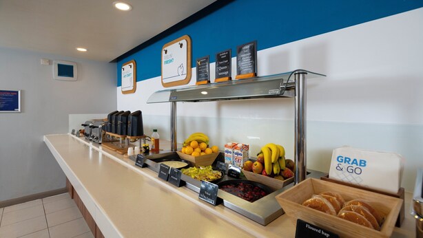 A buffet counter with various food items and a sign indicating 'Grab & Go' service. - Holiday Inn Express Taunton East by IHG (Taunton)