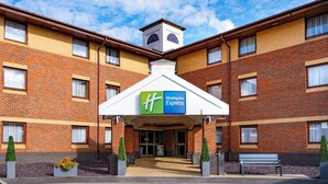 A Holiday Inn Express hotel with a brick facade, a central entrance, and a small tower-like structure above the entrance. - Holiday Inn Express Taunton East by IHG (Taunton)