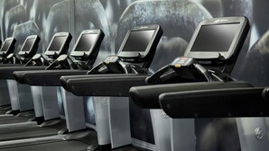 A row of stationary bikes with digital screens and a FlexDeck shock absorption system.