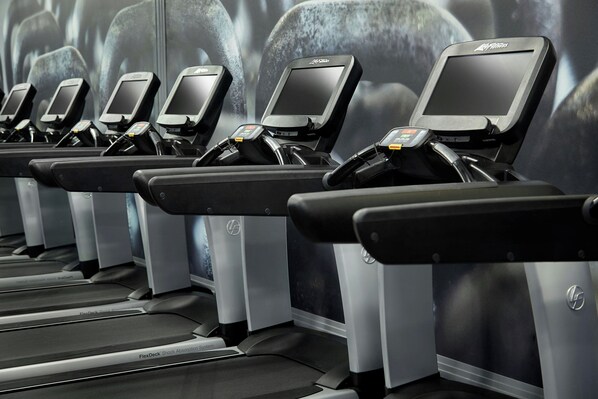 A row of stationary bikes with digital screens and a FlexDeck shock absorption system.
