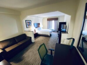 A hotel room with a bed, a desk, a chair, and a sofa. - Holiday Inn Express Ft Payne by IHG (Fort Payne)