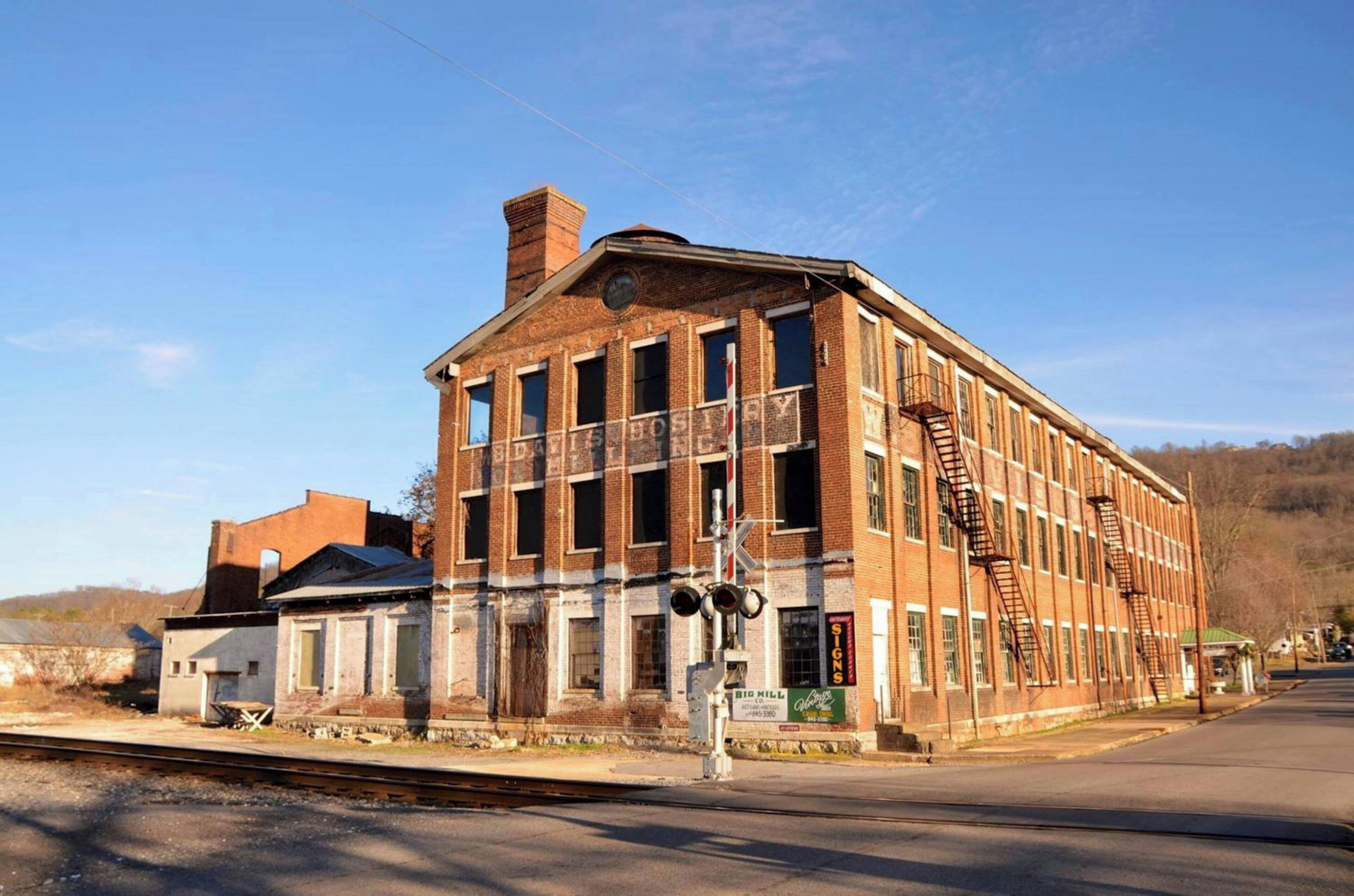 A large brick building with multiple windows and a fire escape.