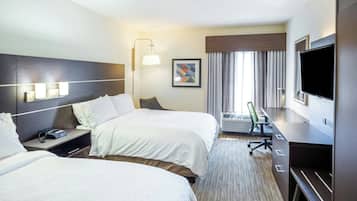 Quarto de hotel com duas camas, uma escrivaninha, televisão e um quadro na parede.
