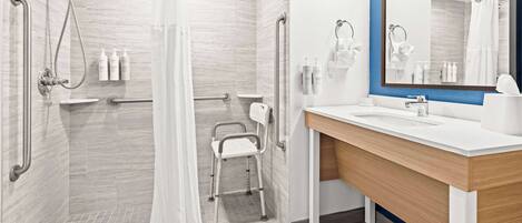 A modern bathroom with a shower, toilet, and sink.