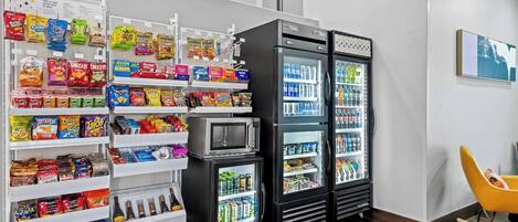 A snack and beverage area with shelves stocked with chips, snacks, and bottled drinks.