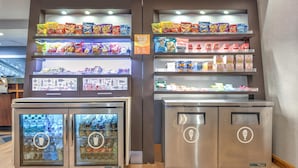 Een automaatruimte met diverse snacks en drankjes, inclusief een drankdispenser.