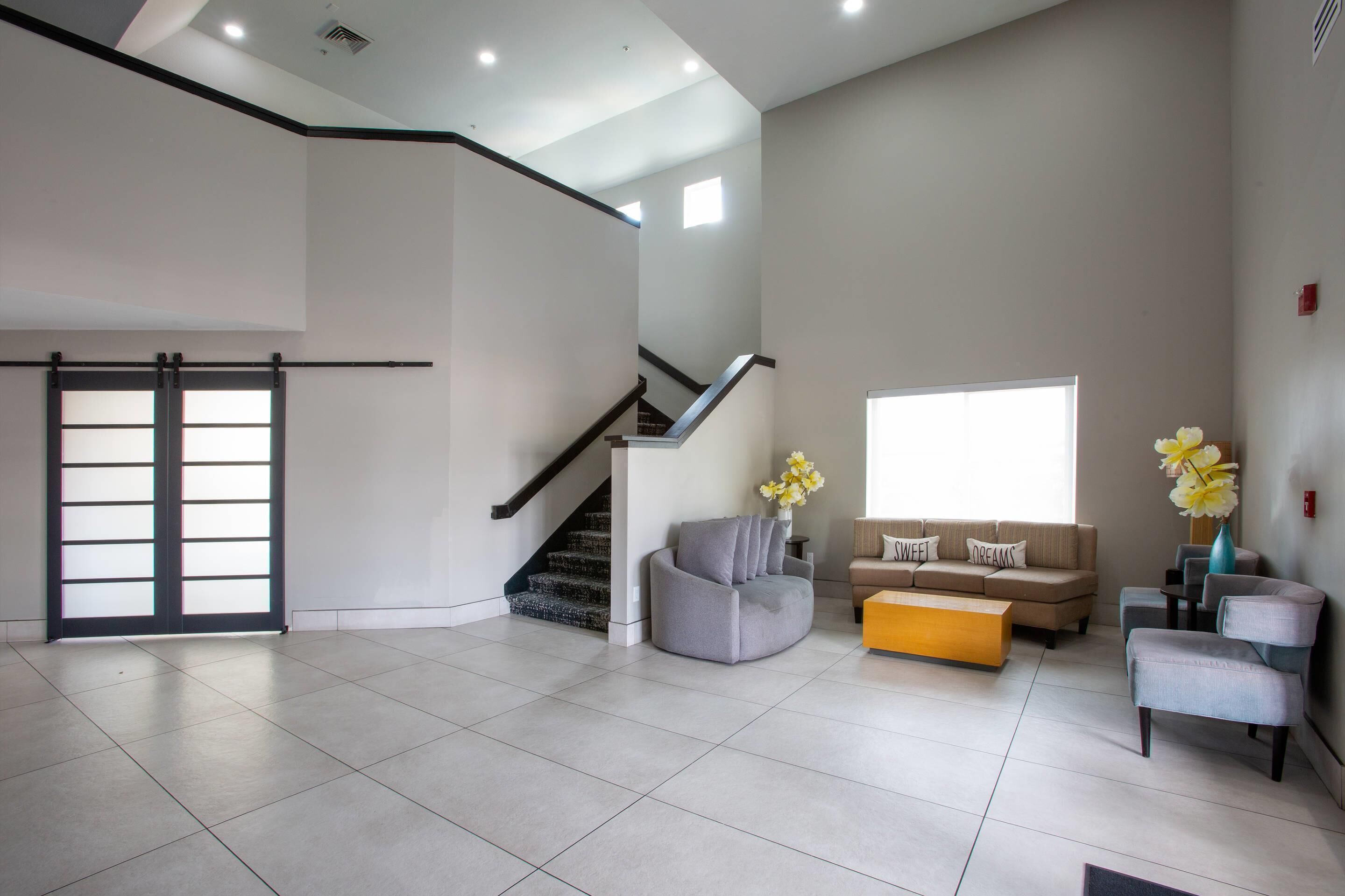A spacious living area with a staircase, a sofa set, and a coffee table.
