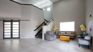 A spacious living area with a staircase, a sofa set, and a coffee table.