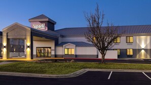 A hotel with a 'spark by Hilton' sign, a parking lot, and a well-lit entrance. - Spark by Hilton Bentonville (Bentonville)