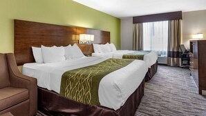 Une chambre d’hôtel avec deux lits, un bureau et une chaise.