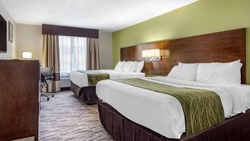 Une chambre d’hôtel avec deux lits, un bureau et une chaise.