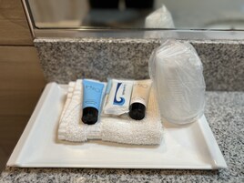 Toiletartikelen op een witte schaal op een granieten aanrecht.