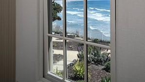 Una ventana con vista al océano y un muelle.