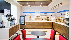 A modern café interior with a self-service counter, seating area, and various food display sections. - Holiday Inn Express San Francisco Union Square by IHG (San Francisco)