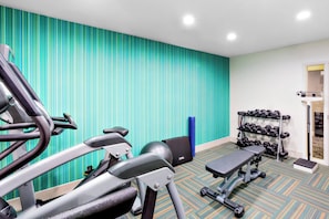 A gym with exercise equipment, a wall with vertical stripes, and a patterned carpet. - Holiday Inn Express San Francisco Union Square by IHG (San Francisco)