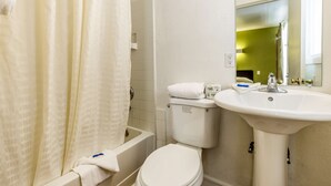 A bathroom with a toilet, sink, and shower area.