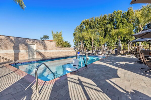 Una piscina al aire libre, tumbonas