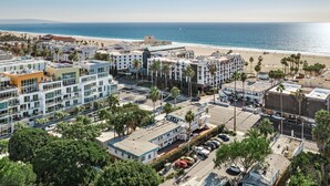 Une zone urbaine côtière, avec des bâtiments modernes, une plage et une vue dégagée sur l’océan.