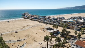 Vue sur la plage avec une jetée, un espace de stationnement et des commodités pour les visiteurs.