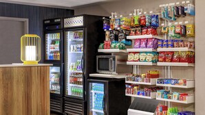 Un espace libre-service équipé d’un réfrigérateur, d’un four à micro-ondes et de distributeurs automatiques.
