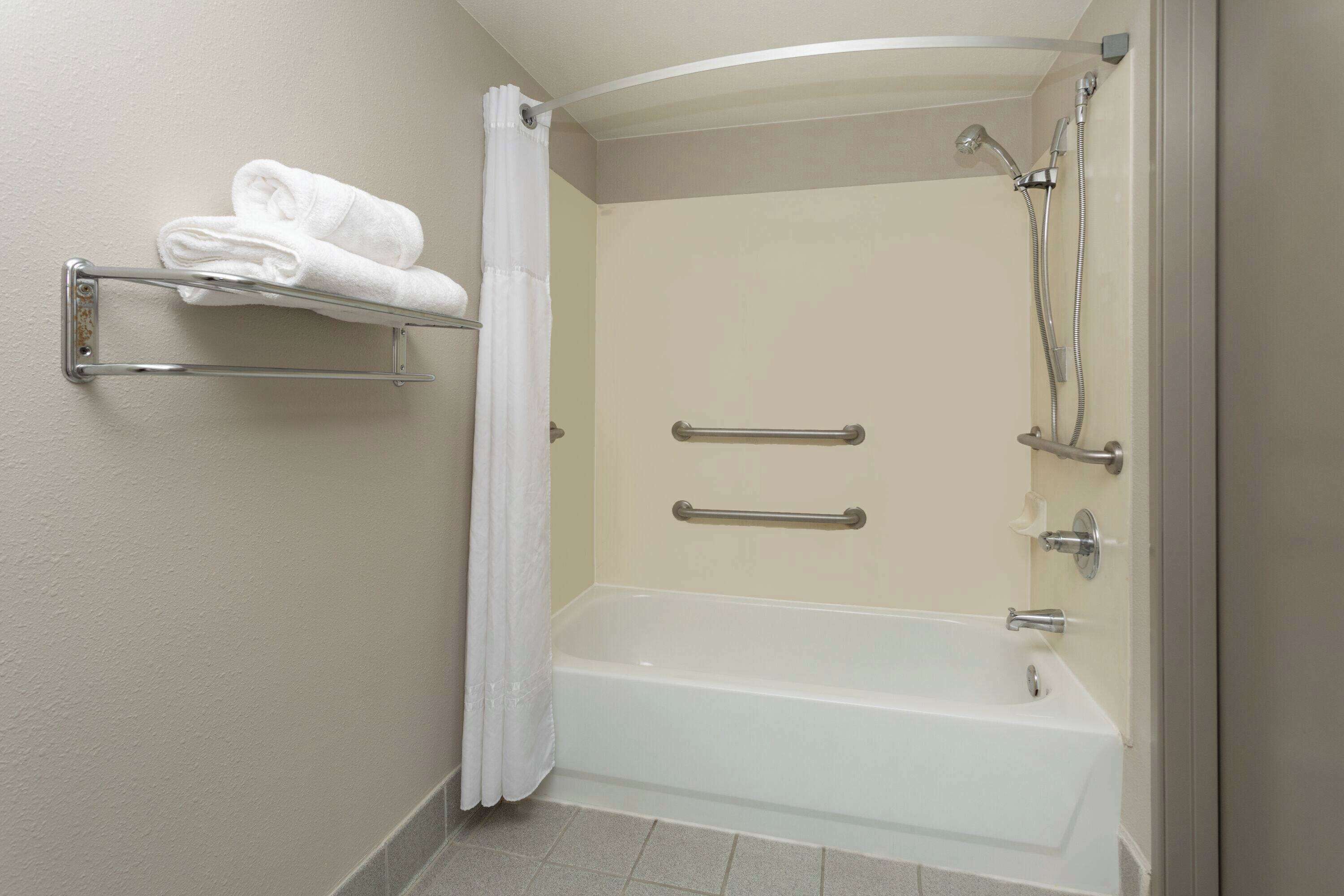 Une salle de bain moderne équipée d’une baignoire, d’une douche et d’un porte-serviettes.