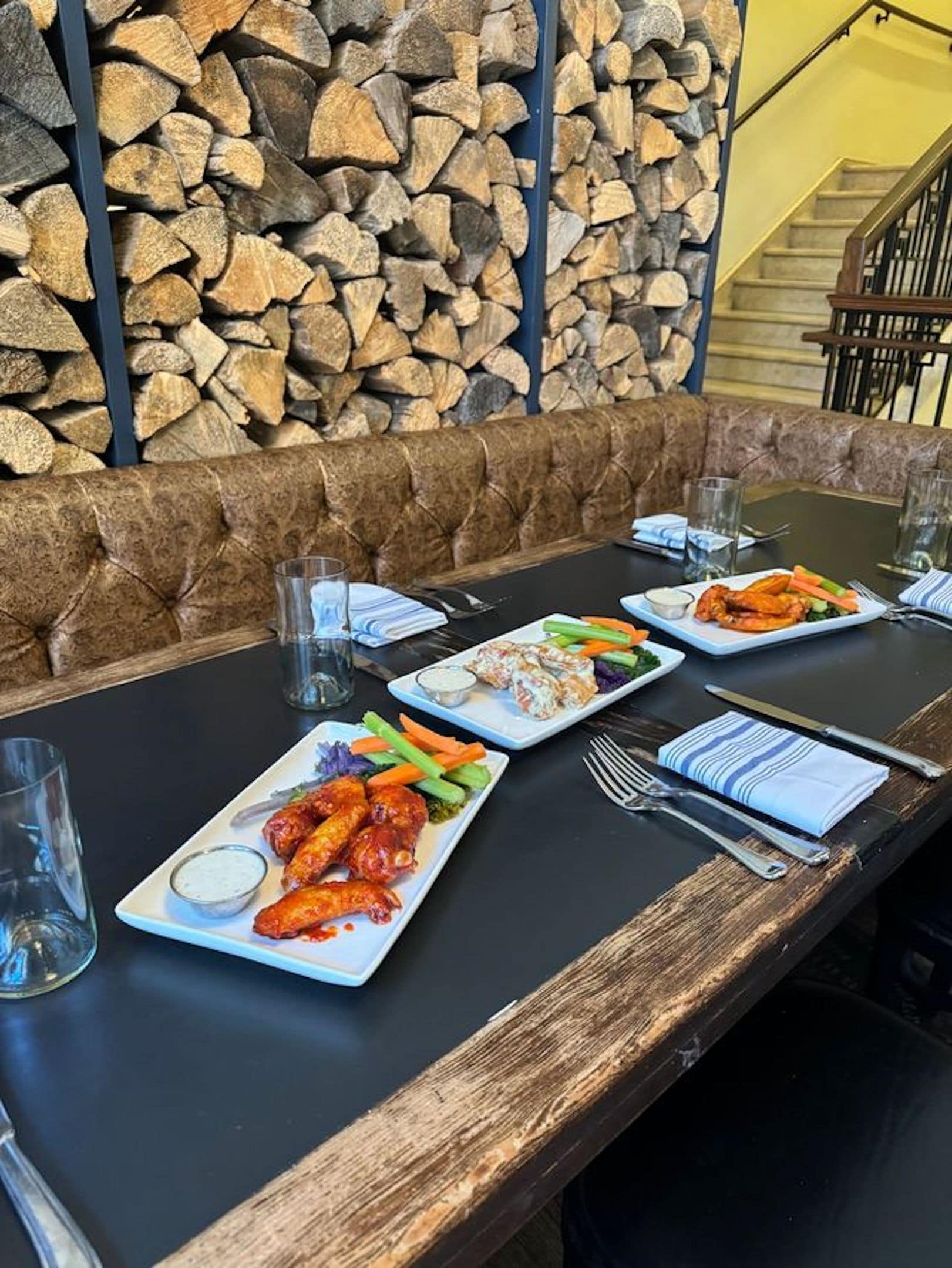 A dining table with plates of food, glasses, and cutlery.