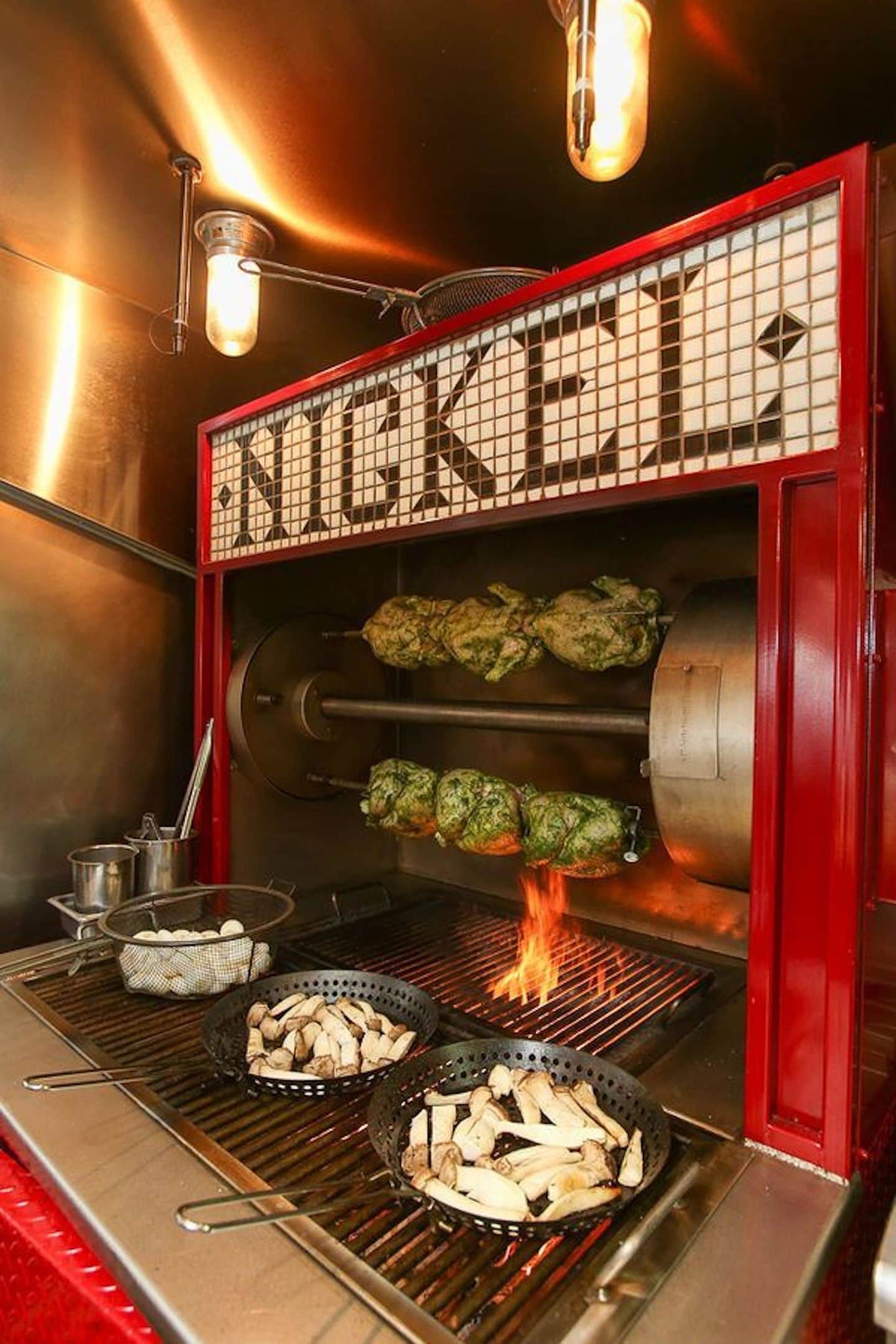 A commercial kitchen with a grill, cooking equipment, and a branded sign.